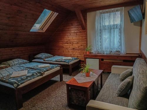 リベレツにあるPenzion Rudolfのベッド2台とソファが備わる客室です。