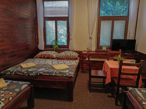 a bedroom with two beds and a desk and a table at Penzion Rudolf in Liberec
