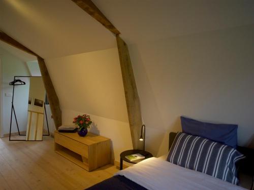 - une chambre avec un lit et une table fleurie dans l'établissement Maisonnette FREA, à Rozebeke