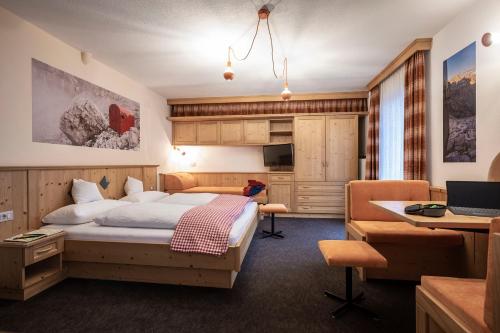 una camera d'albergo con letto e scrivania di Garni Reider a Sesto