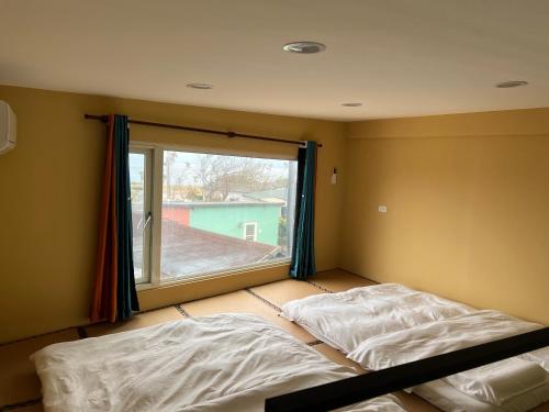 a bedroom with two beds in front of a window at 自然海naturalhigh in Dahan