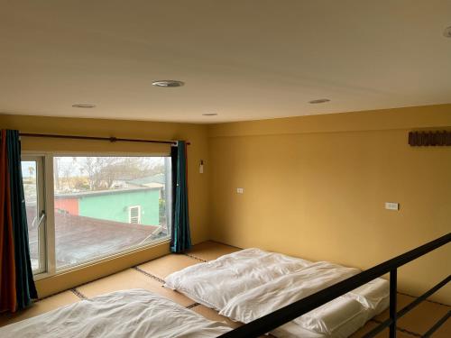 a bedroom with a bed and a large window at 自然海naturalhigh in Dahan