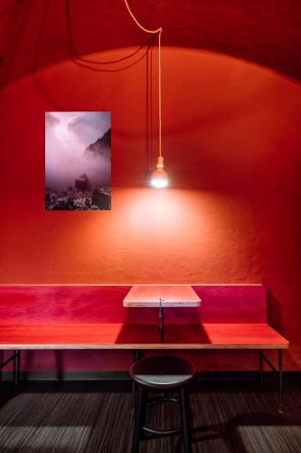 a red room with a bench and a picture at Garni Reider in Sesto