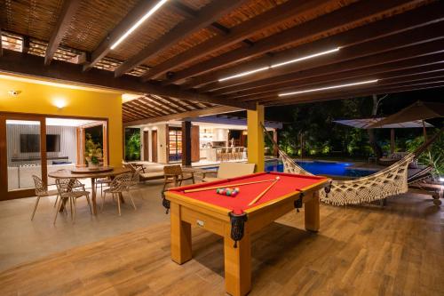 a room with a pool table and a hammock at Sauipe House D10 - Mansão 6 suítes com luxo e conforto in Costa do Sauipe