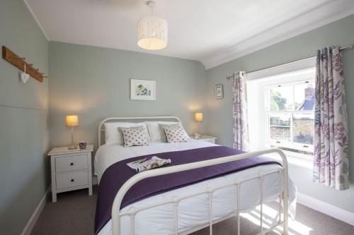 una camera con un letto bianco e una finestra di Moorside Cottage ad Ampleforth