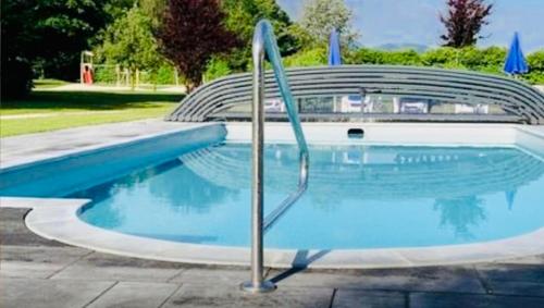 a swimming pool with a metal railing next to it at Familien-Appartement #10 Obermoosen in Übersee