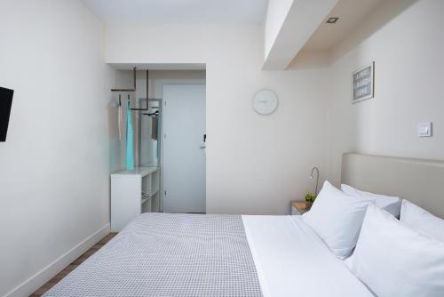 a bedroom with a white bed with white pillows at Enattica Syntagma Living in Athens