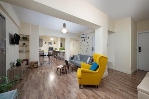 a living room with a yellow chair and a couch at Enattica Syntagma Living in Athens