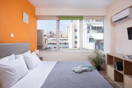 a bedroom with a bed and a large window at Enattica Syntagma Living in Athens