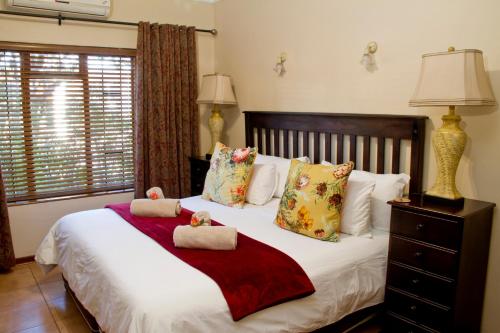 a bedroom with a bed with two towels on it at Del Roza Guest House in Middelburg