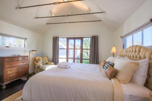 a bedroom with a large white bed and a chair at Liberty Tree House in Charleston