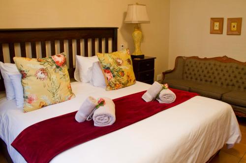 a hotel room with two towels on a bed at Del Roza Guest House in Middelburg