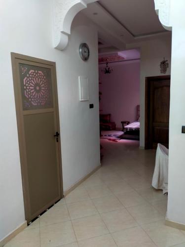 una habitación con una puerta con un reloj en la pared en Safi capitale de l'océan en Safi
