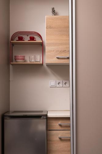 a refrigerator in a kitchen with wooden cabinets at Enattica Syntagma Living in Athens