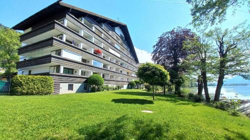 a building on a grassy hill next to a building at ANJA Seeblickappartement Haus Hänsel u Gretel am Ossiacher See, Hallenbad, Skiarena Gerlitzen in Unterberg