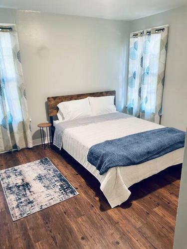 ein Schlafzimmer mit einem Bett mit einer blauen Decke darauf in der Unterkunft 3 Bedroom Home Away From Home. in West Monroe