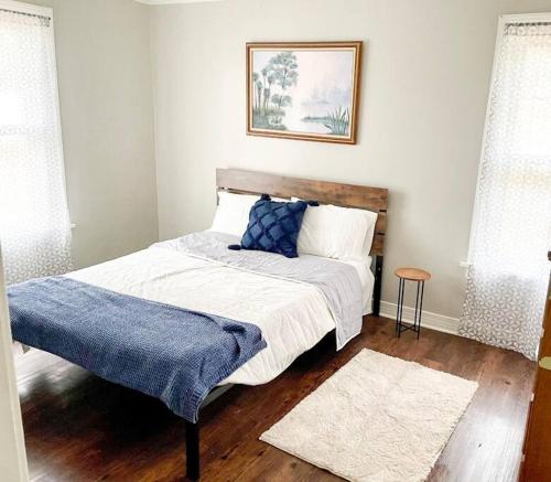 ein Schlafzimmer mit einem Bett mit einer blauen Decke darauf in der Unterkunft 3 Bedroom Home Away From Home. in West Monroe