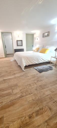 a bedroom with a large bed and a wooden floor at appart central et son parking privatif gratuit in Collioure