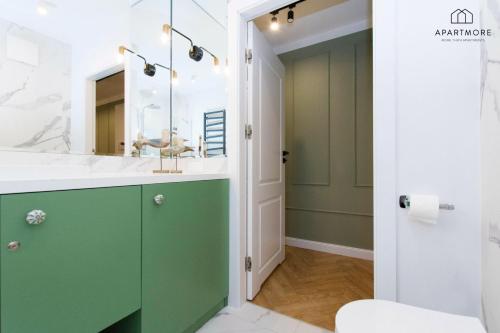 a bathroom with a green vanity and a mirror at Rezydencja Wintera by Apartmore in Gdańsk