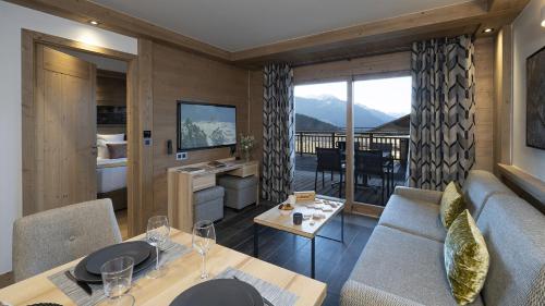 una sala de estar con un sofá y una mesa en MGM Hôtels & Résidences - Résidence Alpen Lodge, en La Rosière