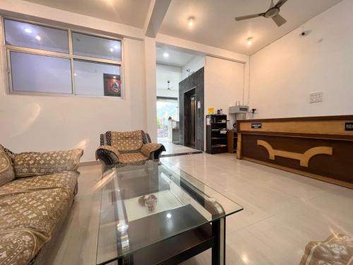 a living room with a couch and a glass table at Hotel Manikut in Rishīkesh