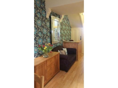 a living room with a couch and a mirror at Diamonds Guest House in York