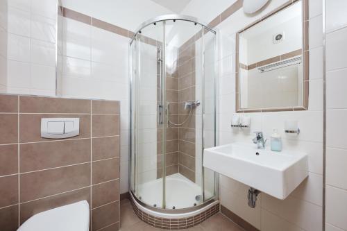 a bathroom with a shower and a sink and a toilet at Hotel Roosevelt in Litoměřice