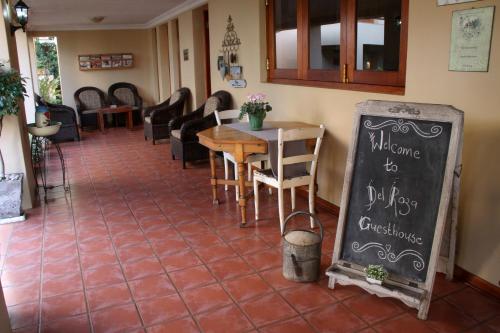 a restaurant with a table and chairs and a chalkboard at Del Roza Guest House in Middelburg