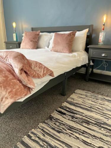 1 dormitorio con cama con almohadas y alfombra en The Cottage, Watergate, Sleaford, en Lincolnshire