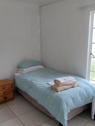 um quarto com uma cama com toalhas em Outside room em Pretoria