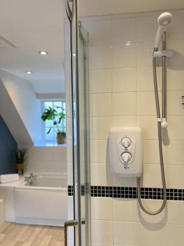 a bathroom with a shower with a soap dispenser at The Cottage, Watergate, Sleaford in Lincolnshire