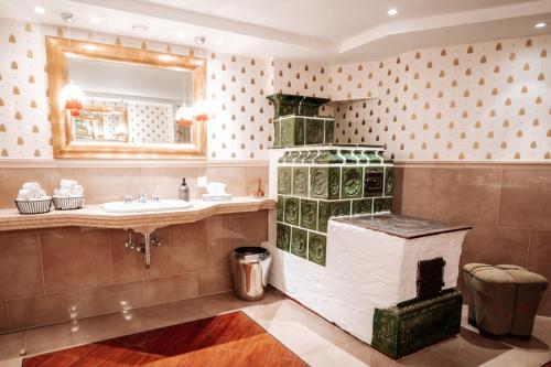 łazienka z kominkiem obok umywalki w obiekcie Hubertus Boutiquehotel Filzmoos w mieście Filzmoos