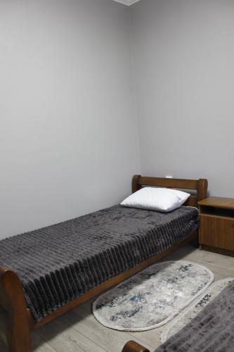 a bedroom with a bed and a white wall at Margo in Yaremche