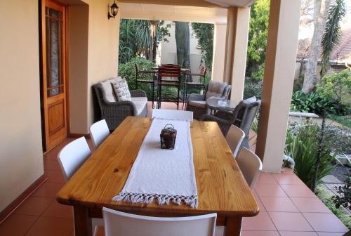 a wooden table and chairs on a patio at Del Roza Guest House in Middelburg