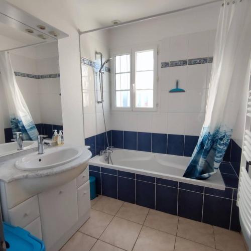 a bathroom with a tub and a sink and a bath tubermottermott at Maison moderne au centre d'Oléron in Dolus d'Oléron