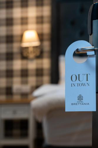 a sign that reads out in town is hanging on a door at Brettania Hotel in Ioannina