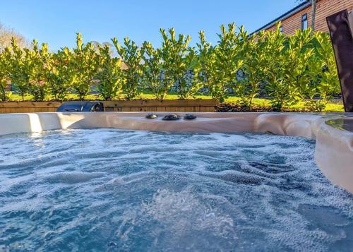 a large jacuzzi tub in a backyard at The Warrens At Foxtail in Chirk