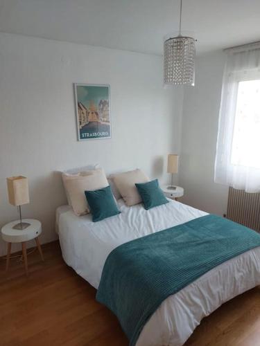 une chambre avec un grand lit blanc avec des oreillers bleus dans l'établissement Le VI, à Colmar