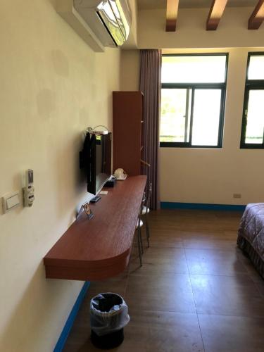 a room with a desk with a television and a bed at Lohas Seaview B&B in Beigan