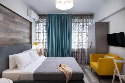 a bedroom with a bed and a yellow chair at Enattica Syntagma Living in Athens