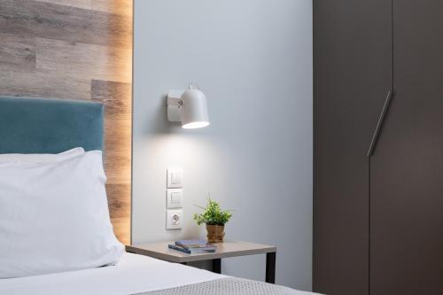 a bedroom with a bed and a table with a plant on it at Enattica Syntagma Living in Athens