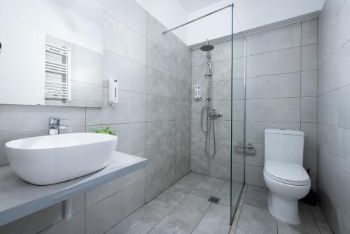 a bathroom with a toilet and a sink and a shower at Enattica Syntagma Living in Athens
