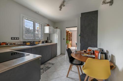 une cuisine avec une table en bois et des chaises jaunes dans l'établissement Grande maison à 1 km de la mer au Pouliguen !, au Pouliguen