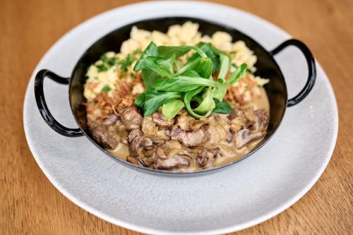 a bowl of food on a plate on a table at Alpendorf Hotel Stern in Sankt Johann im Pongau