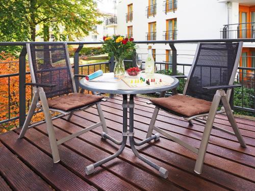 uma mesa e duas cadeiras num deque em Kaiservillen Heringsdorf - Ferienwohnung mit 1 Schlafzimmer und Balkon D214 em Heringsdorf