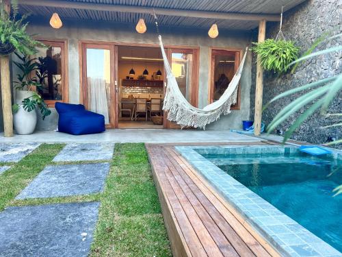 a villa with a hammock and a swimming pool at Casa TUA no Preá pertinho do Mar in Cruz
