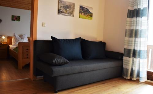 a living room with a couch with pillows on it at Ferienhof Hochbrandt in Spital am Pyhrn