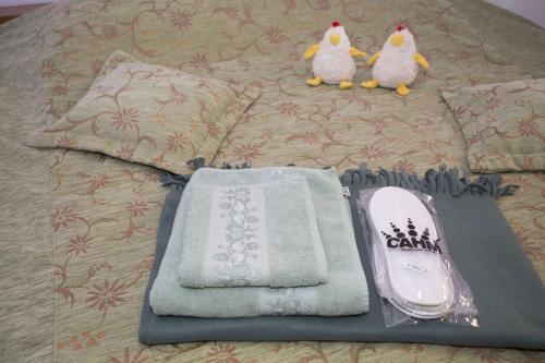 een bed met handdoeken en een telefoon en twee gevulde pinguïns bij CASA CABUZ in Avrig