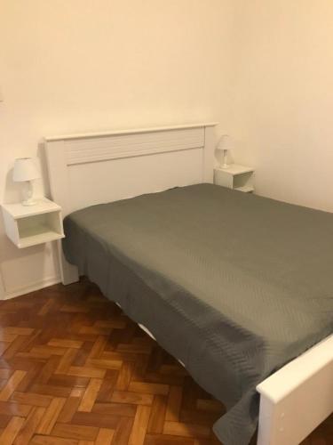 ein Schlafzimmer mit einem Bett mit zwei Nachttischen daneben in der Unterkunft Lindo Apartamento Copacabana in Rio de Janeiro