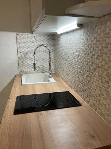 une cuisine avec un évier et un plan de travail dans l'établissement Appart Frontignan sur la plage, piscine, wifi, tv, Netflix, à Frontignan